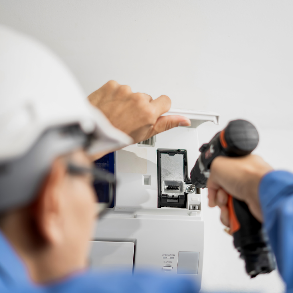Man fixing an air conditioning unit in home