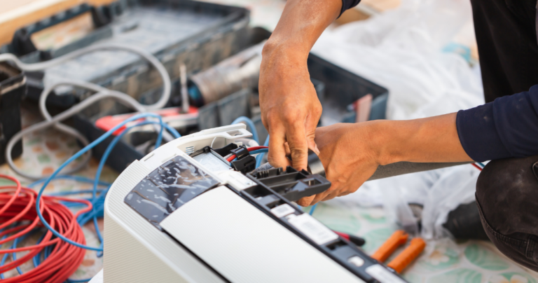 AC repair man fixing an air conditioner